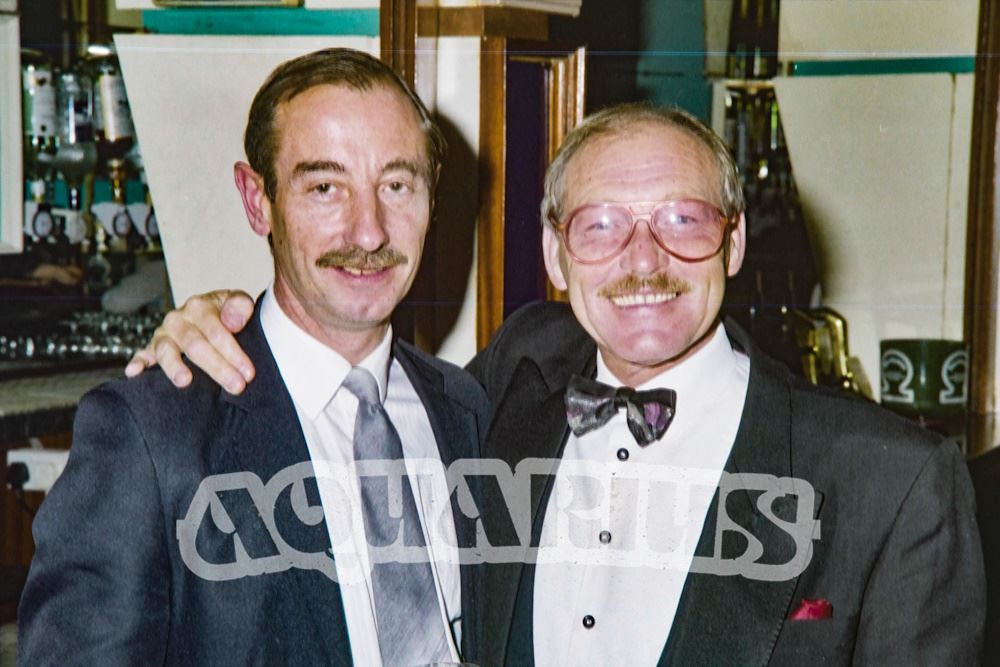 Staff, possibly a manager (left) with compere Tufty Gordon (right)