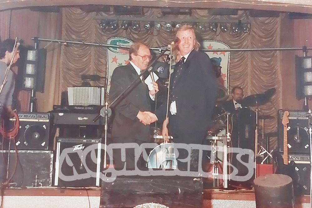 Compere Tufty Gordon on stage with customers, in front of the house band