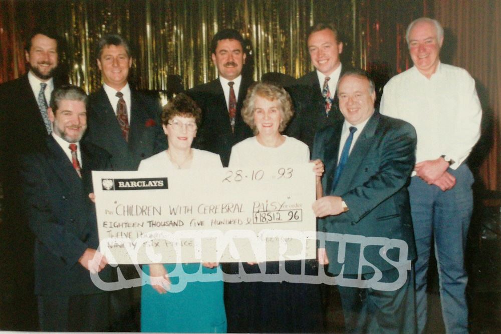 Customers on stage receiving charity cheque