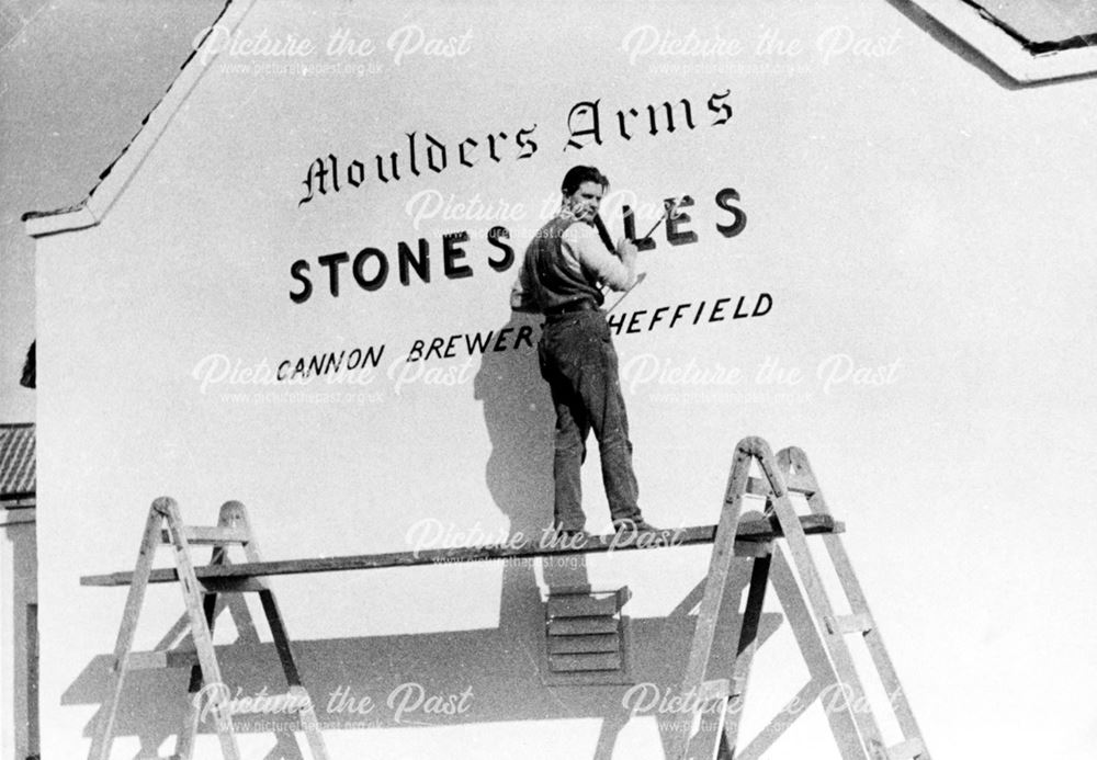Signwriter at work at the Moulders Arms, Church Street, Rddings, c 1900