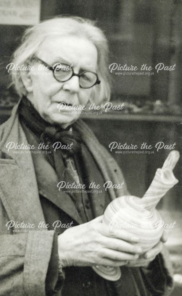 Unidentified individual holding a decorative jug, Buxton