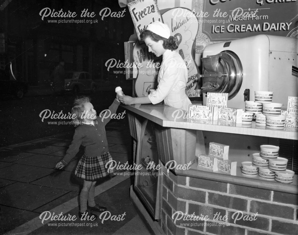 Child being served with ice-cream at counter in Ice-cream parlour, Spring Gardens, Buxton           