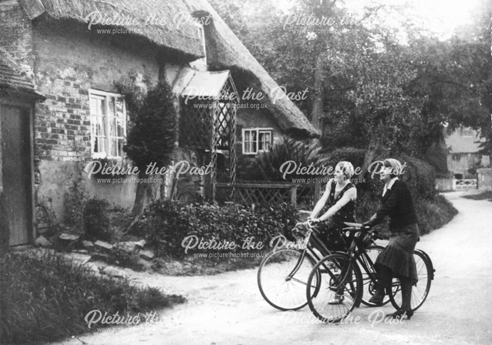 Two lady cyclists looking at the cottages at Hemington Hill