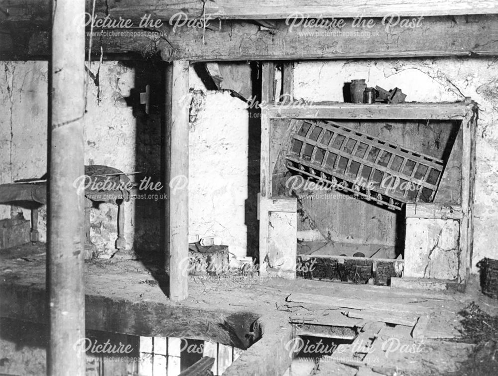 Interior of former mill before restoration, showing old mill machinery.