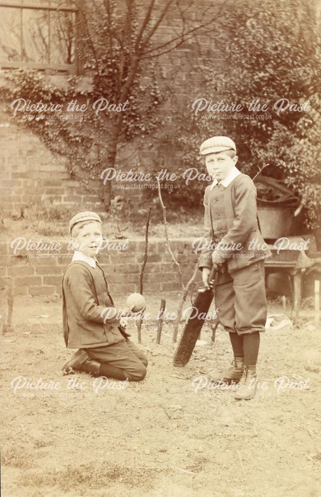 Two boys playing cricket