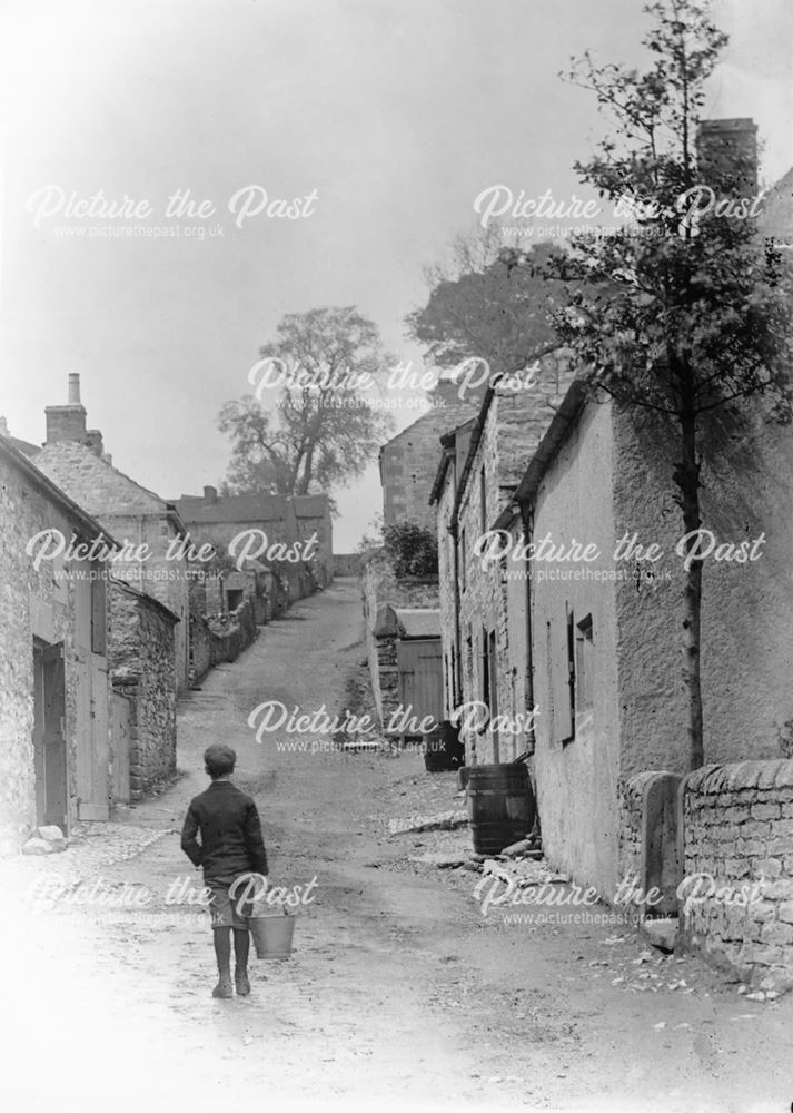 Boy with Pail walking up Village Street, Ashford in the Water, c 1890s