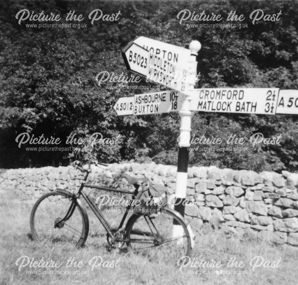 Push Bike Resting on Signpost at Junction A5012, Grange Mill, 1960s