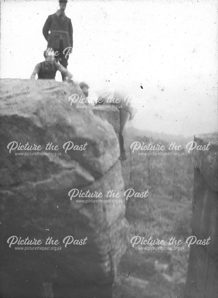 Climbers ascending gritstone pinnacle