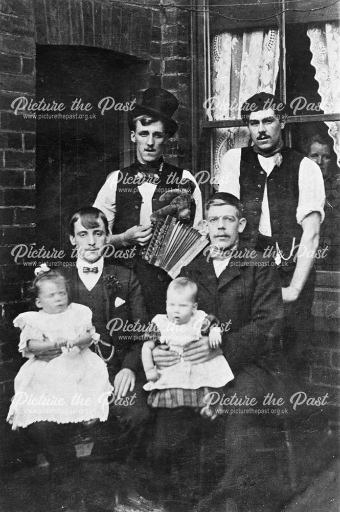 The Grainger Family men and babies sitting outside the back door.