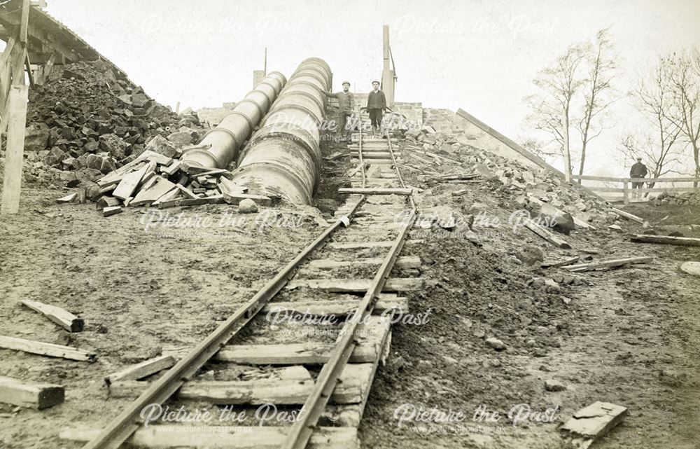 Workers beside a pipe leading from Ambergate Reservoir