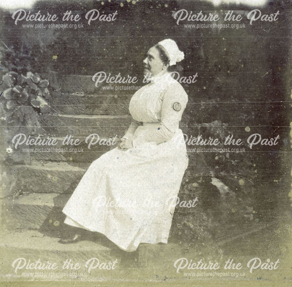 Nurse sitting on the steps in the grounds of the Derby Royal Infirmary