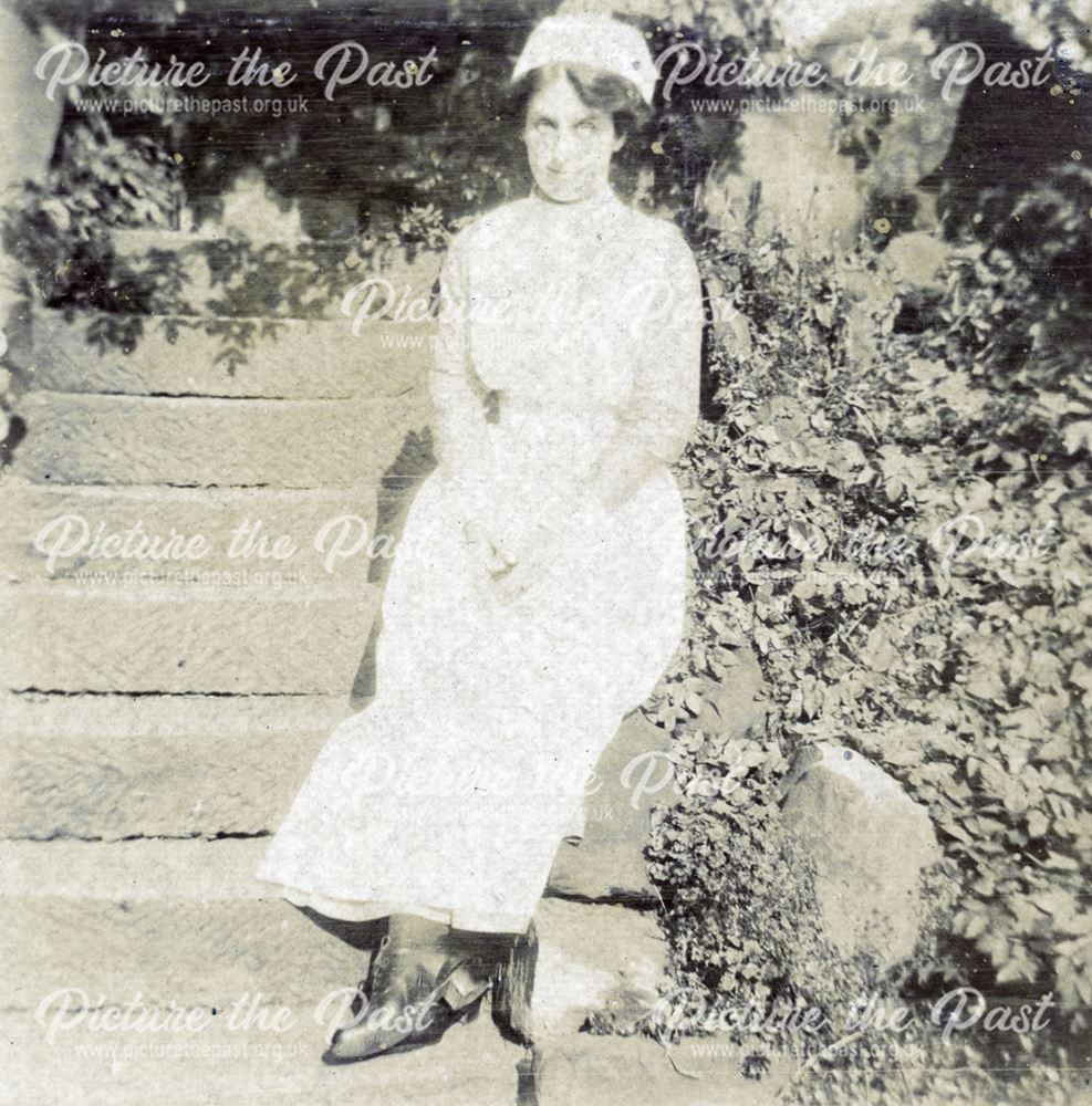 Nurse sitting on the steps in the grounds of the Derby Royal Infirmary