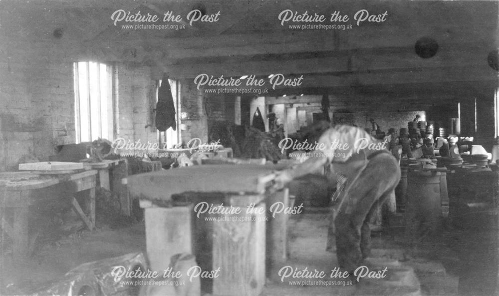 Interior of the workshops, cutting a 'batt' of clay at the brick and sanitary pipe works of W H and 