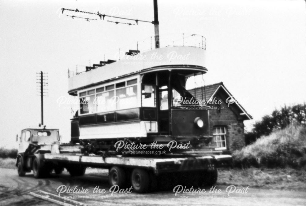 Open topped tram being transported by lorry