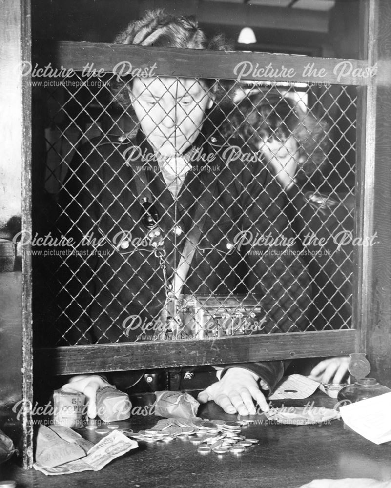 Derby Corporation bus conductress handing in cash