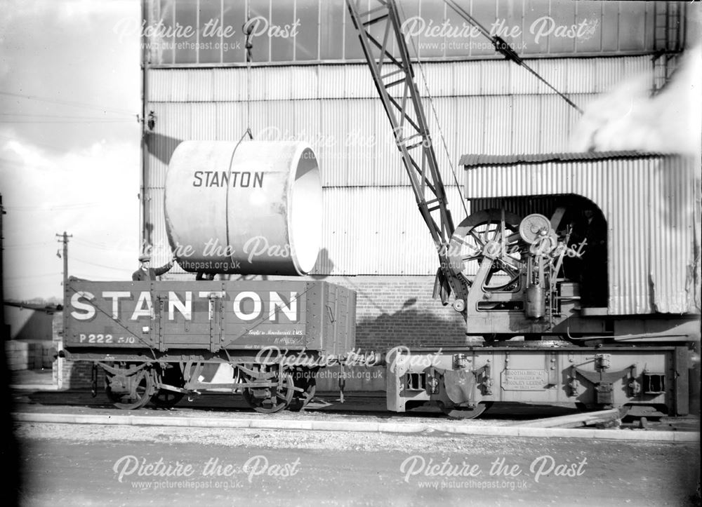 Steam crane loading concrete pipe into a wagon