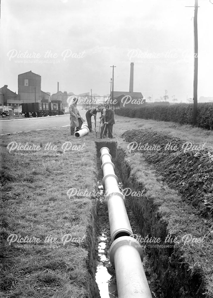 Concrete pipeline being laid in a trench