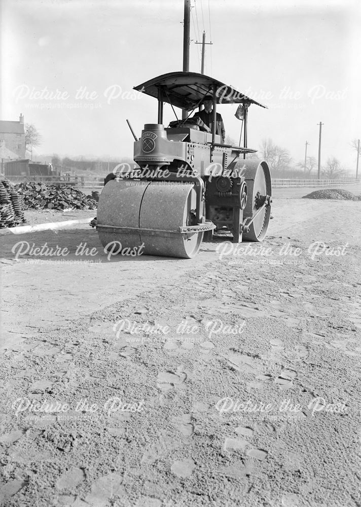 Road roller preparing surface for iron road