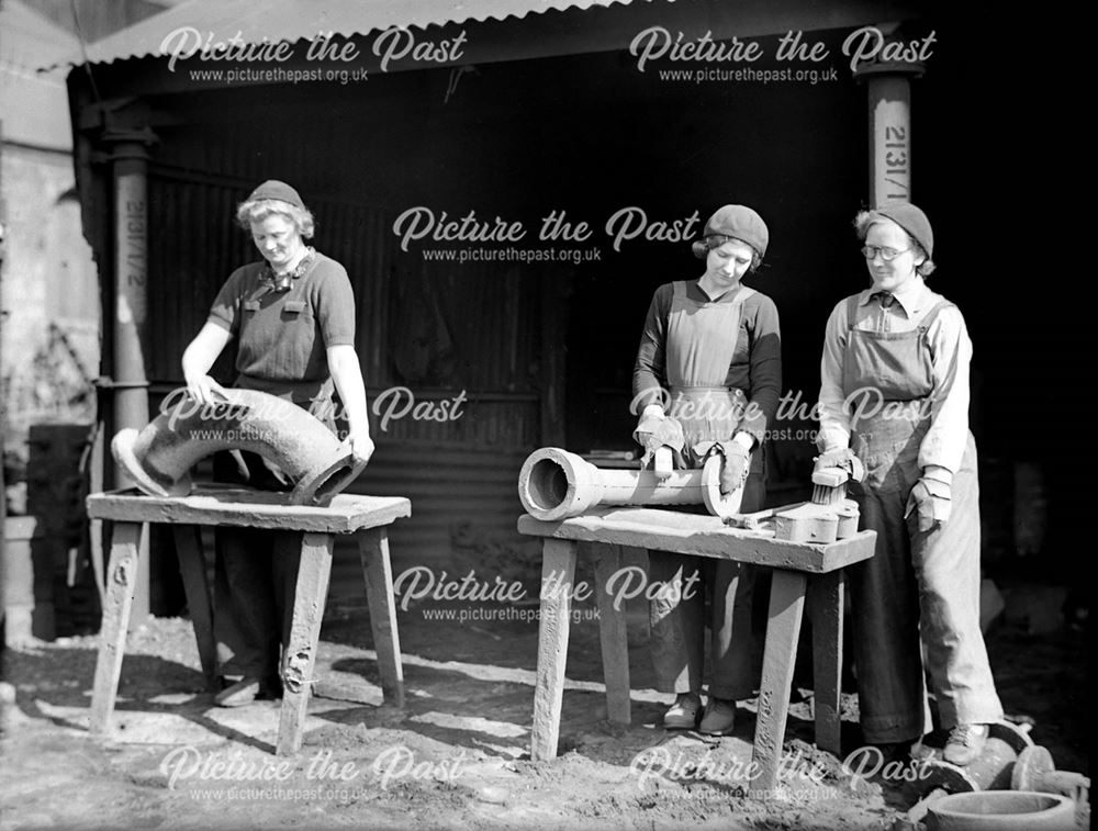 Female employees fettling pipe bends at Riddings Foundry