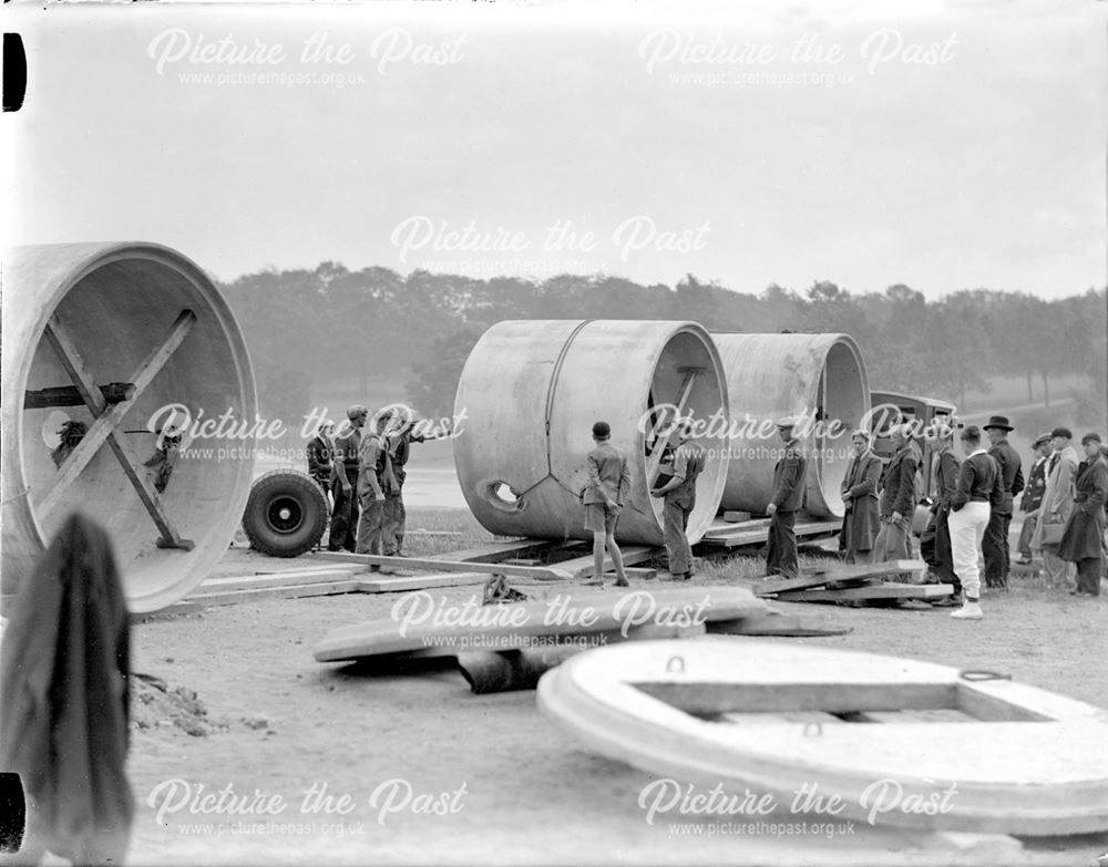 Unloading large diameter concrete pipes for use in air raid shelter construction