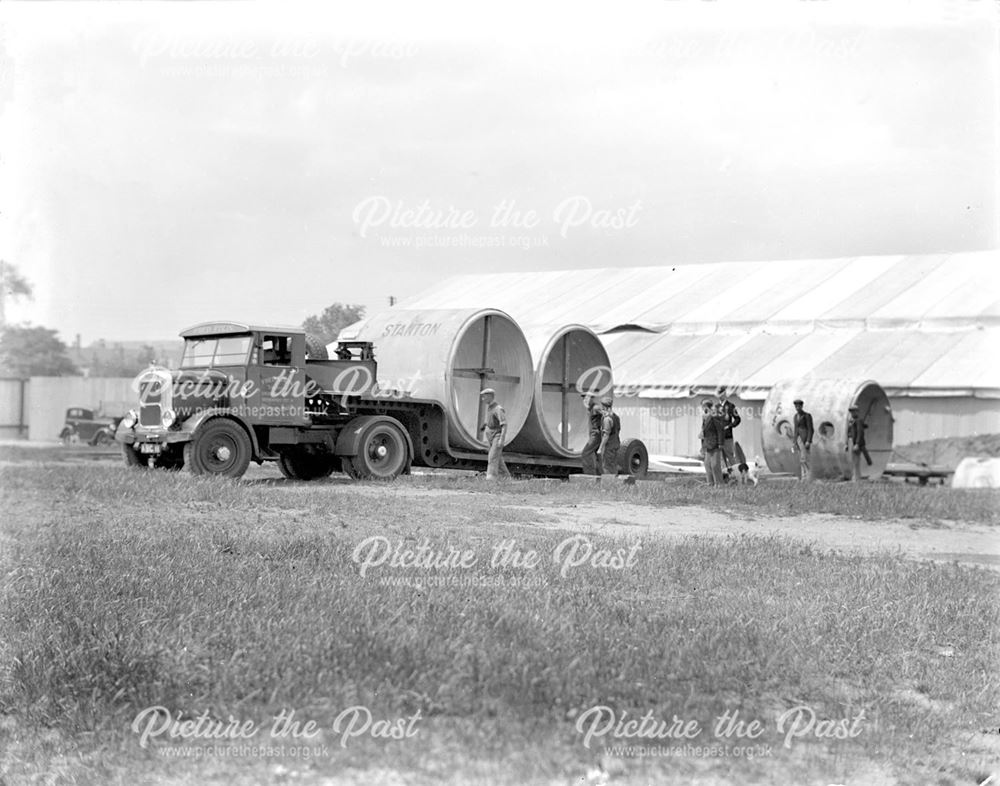 Unloading large diameter concrete pipes for use in air raid shelter construction