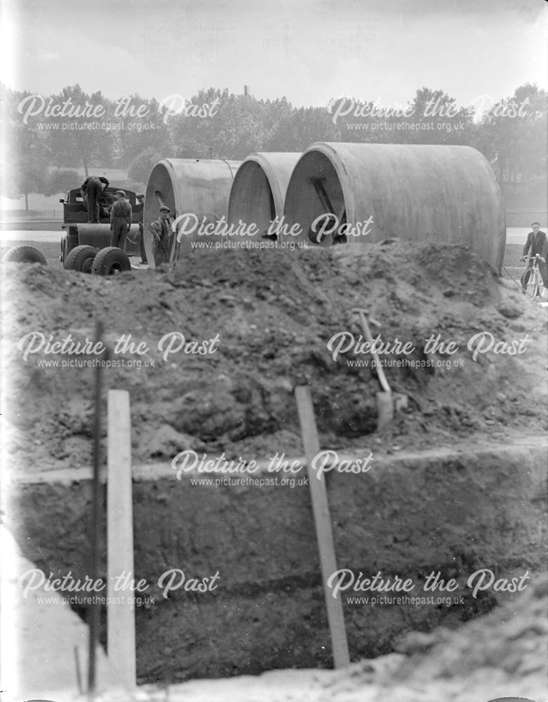 Unloading large diameter concrete pipes for use in air raid shelter construction