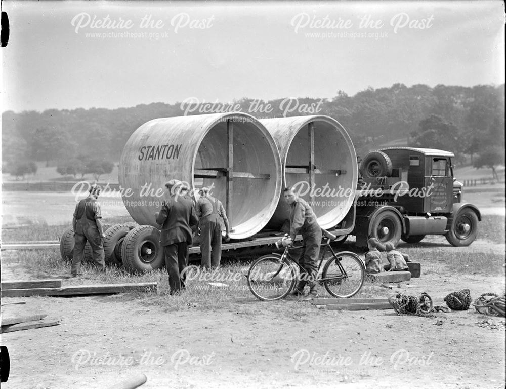 Unloading large diameter concrete pipes for use in air raid shelter construction