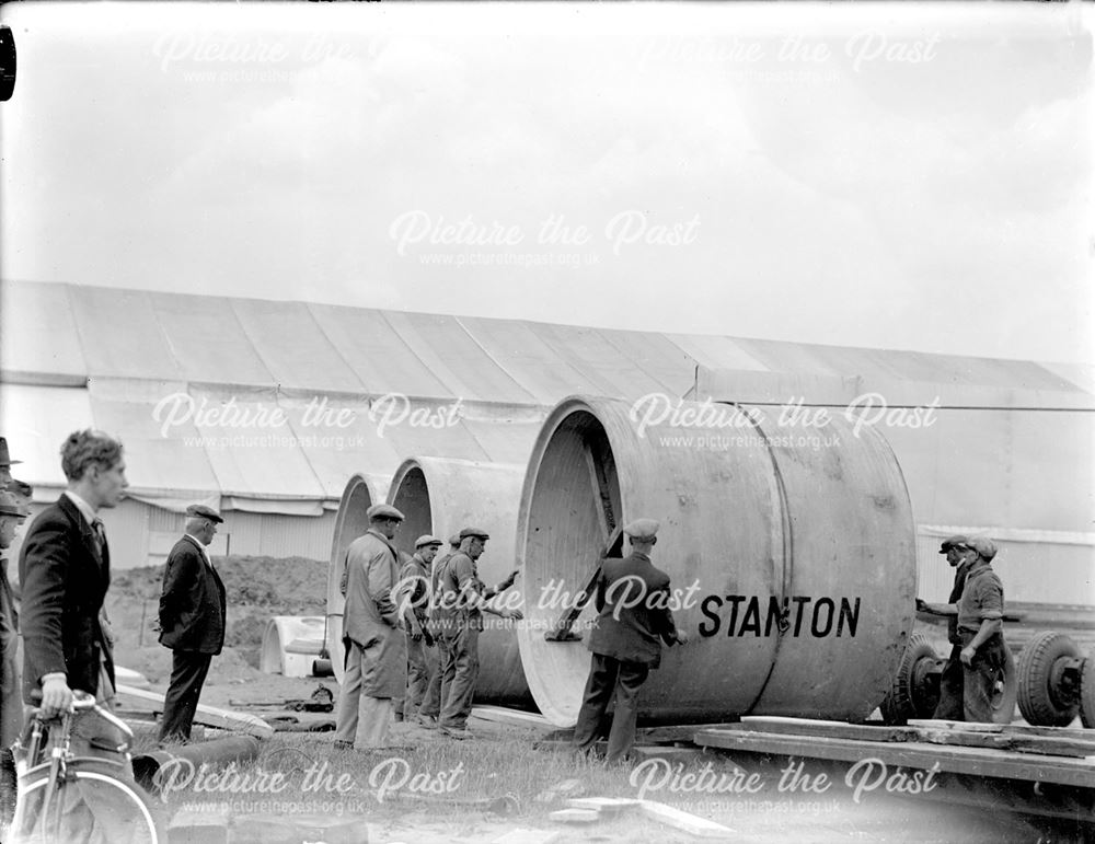 Unloading large diameter concrete pipes for use in air raid shelter construction