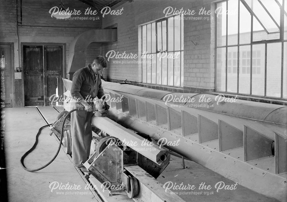Workman grinding a concrete lamp column, 1939