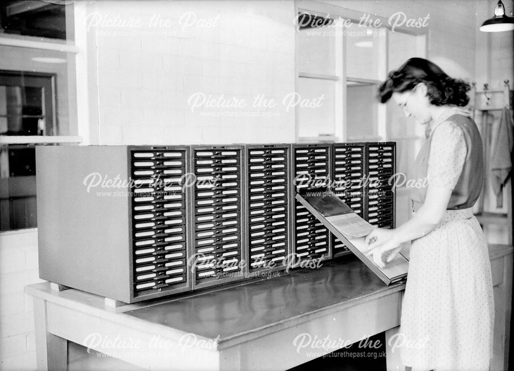 Female employee using filing system in Labour office in Henley House - Stanton Iron Works