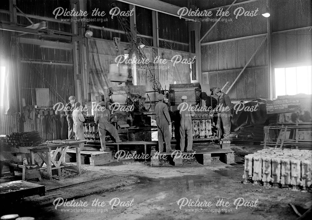 Male employees casting concrete practice rocket heads during World War 2 at Stanton Ironworks