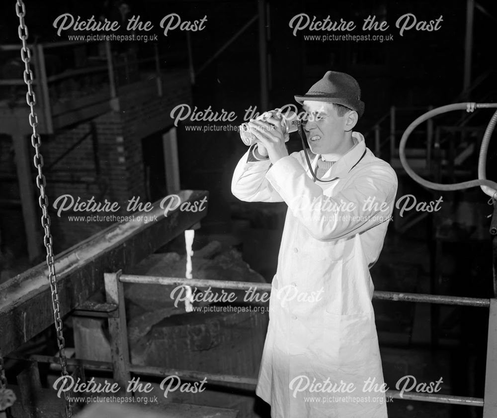 Technician using a optical pyrometer to test temperature of metal