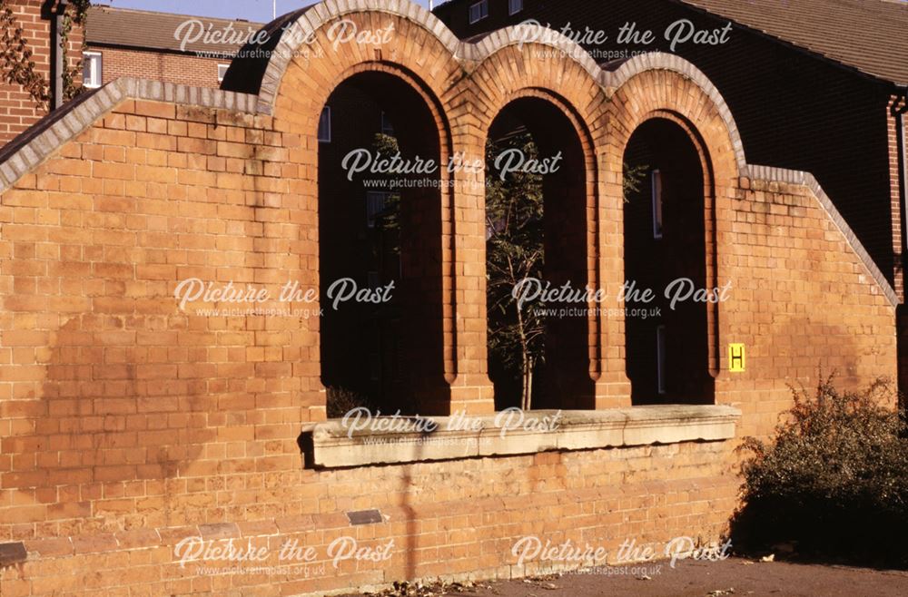 Detail of 3 arched windows in a brick wall