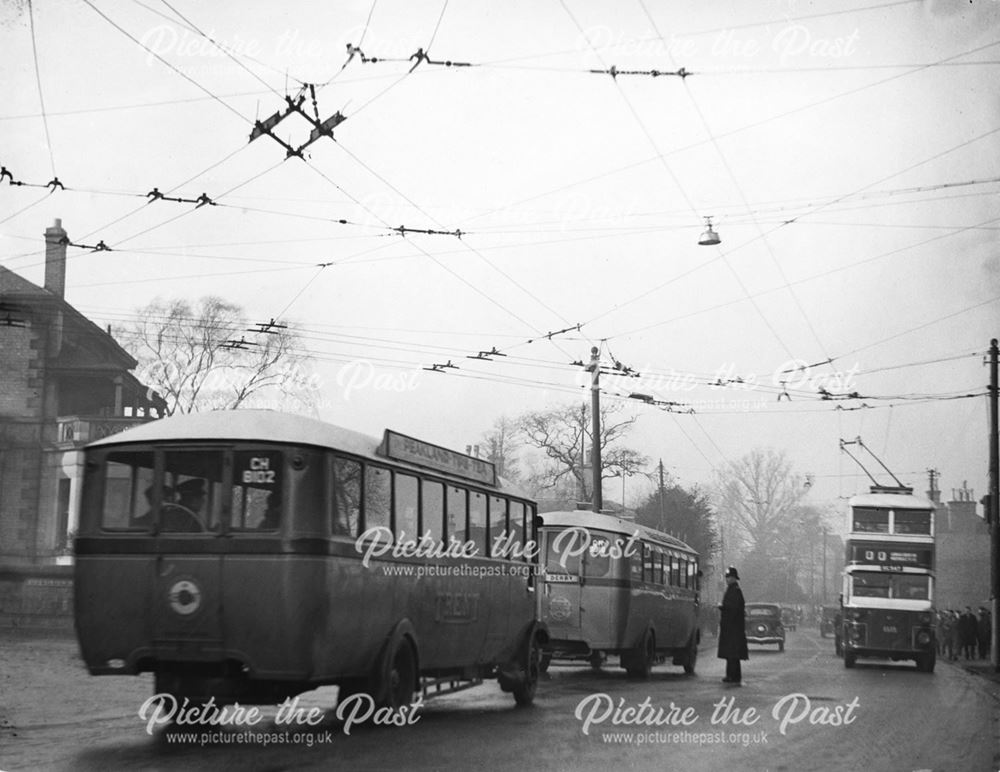 Traffic congestion, trolley bus cables and workers crowd the street on Osmaston Road