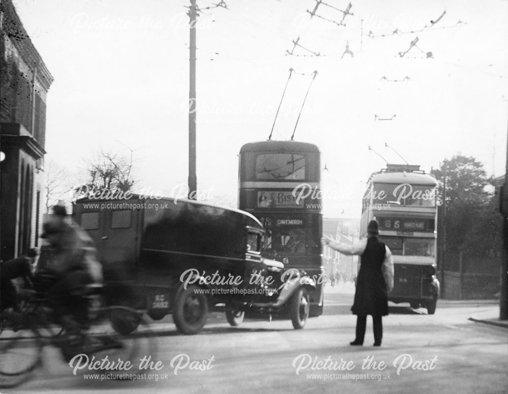 Traffic congestion, trolley buses and workers crowd the street on Osmaston Road