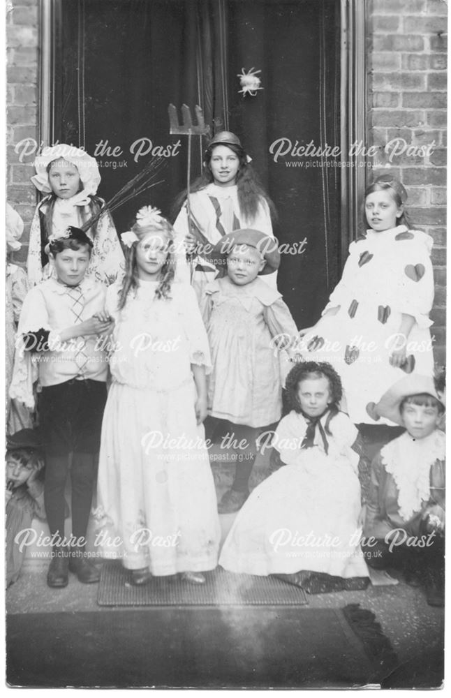 Group of children in fancy dress posed in doorway