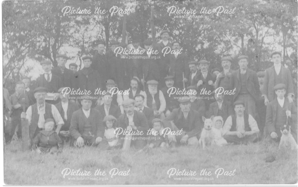 Unidentified group of men, children and dogs