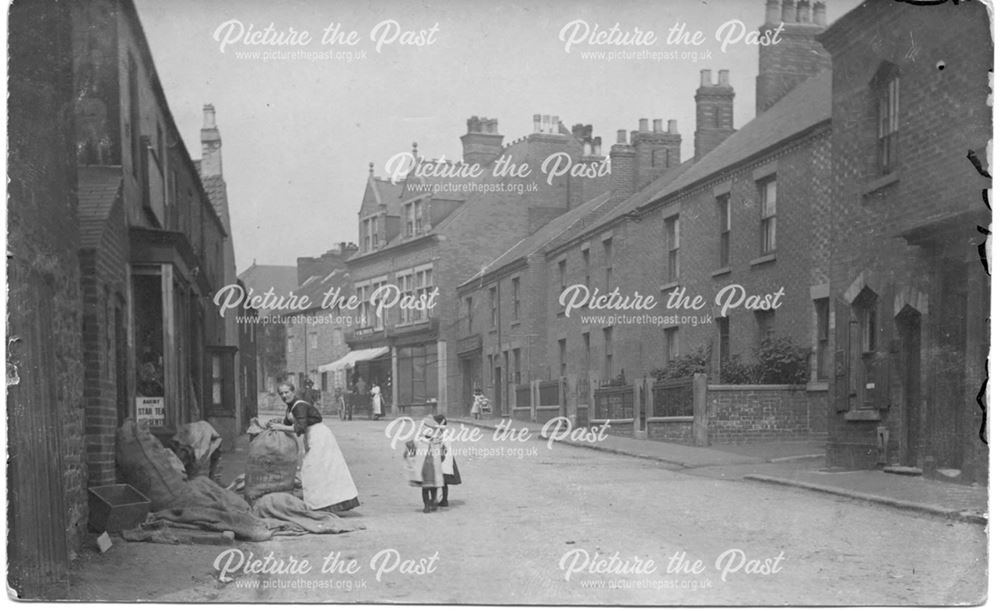 Street scene showing woman moving large sacks.