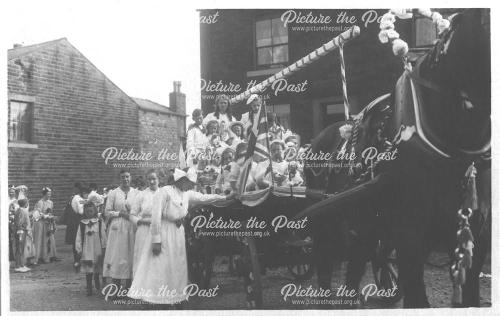 Horse and cart decorated for parade, with large group of mixed people