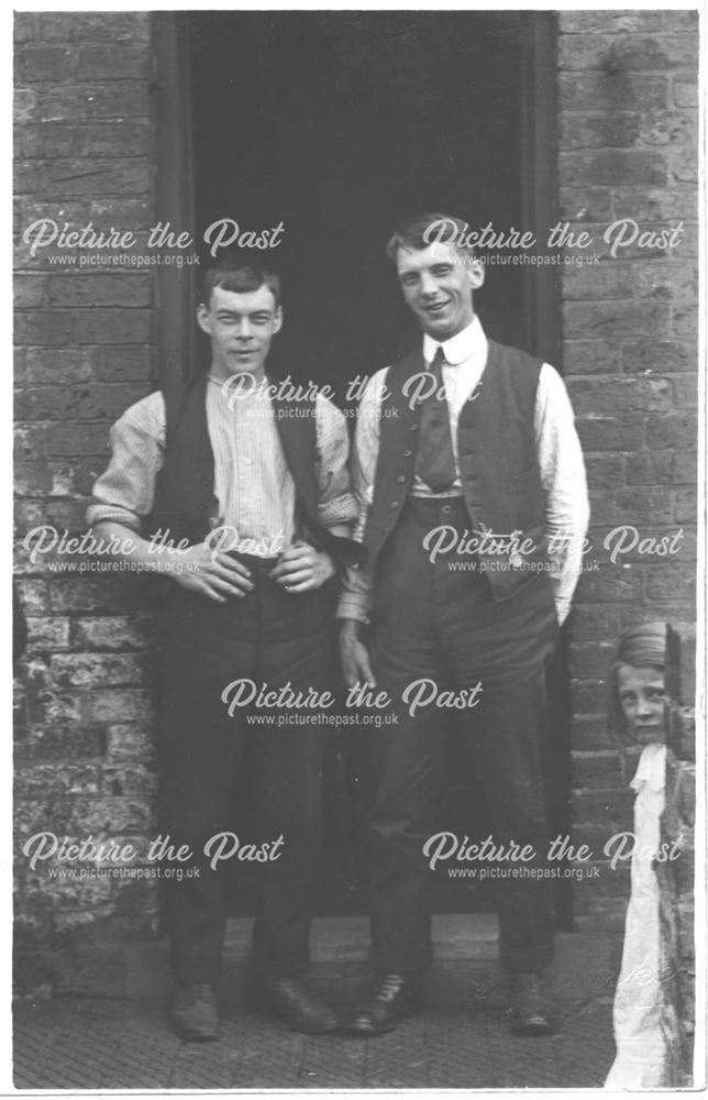 Two young men and young girl in doorway