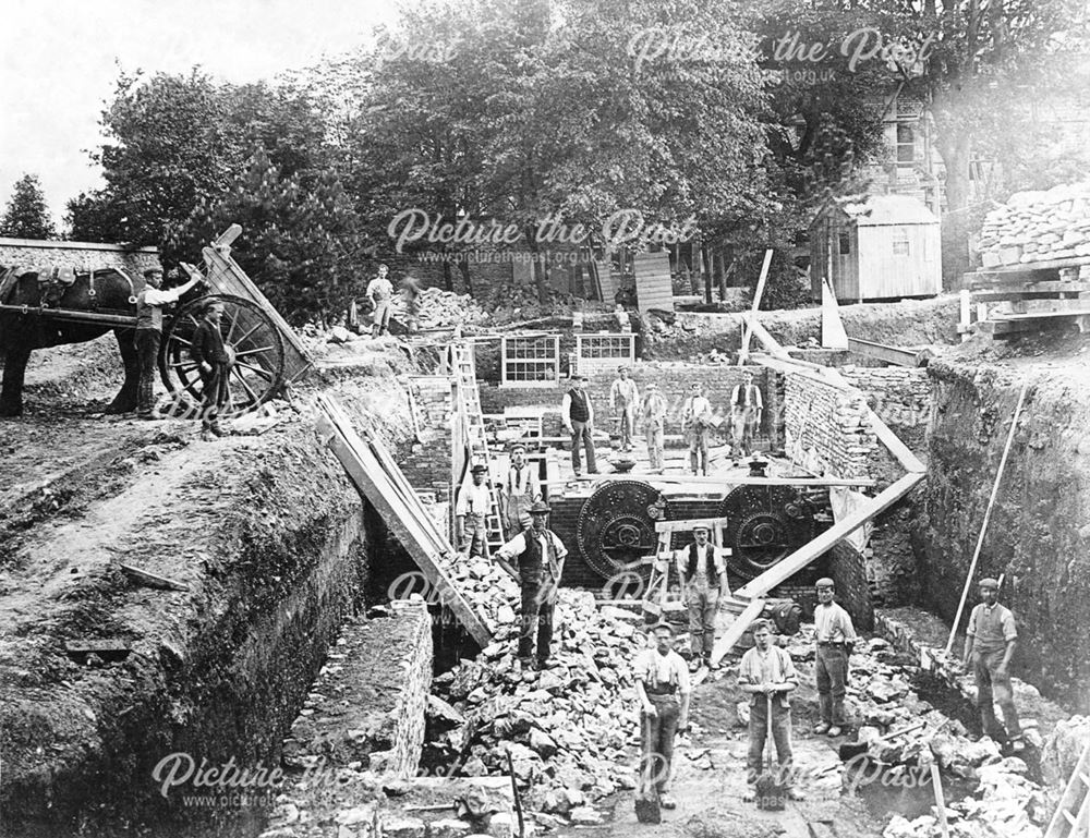 Workmen at the foundation level of a new building.