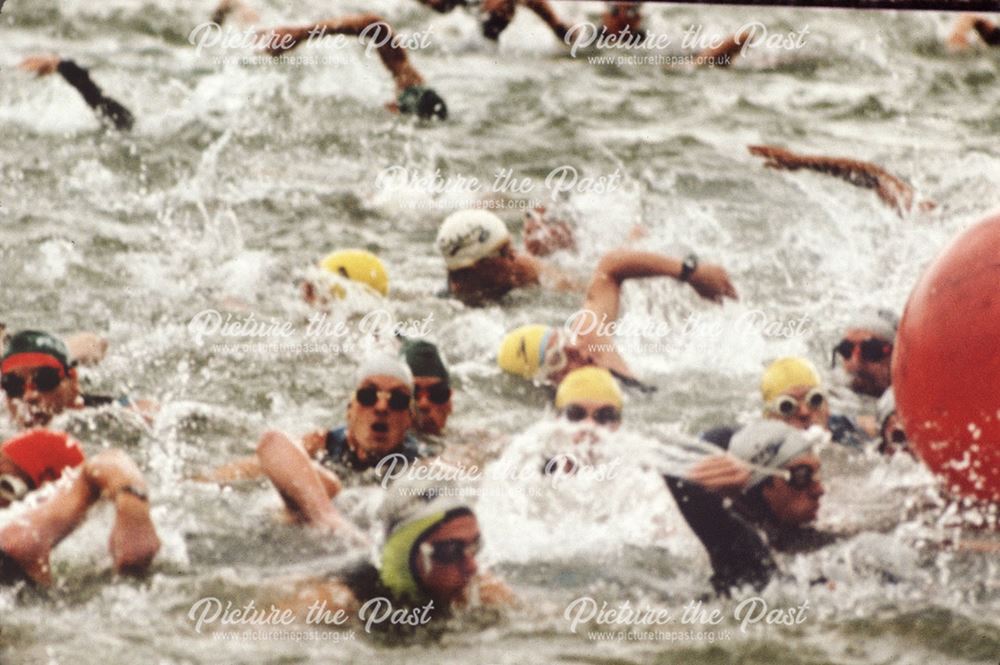 Triathlon event (continuous long-distance swimming, bicycling, and running race) swimmers on the lak