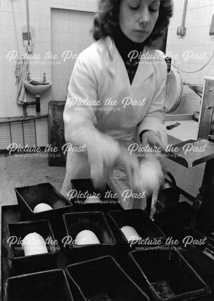 Woman putting breadmaking dough in tins, South Normanton Bakehouse