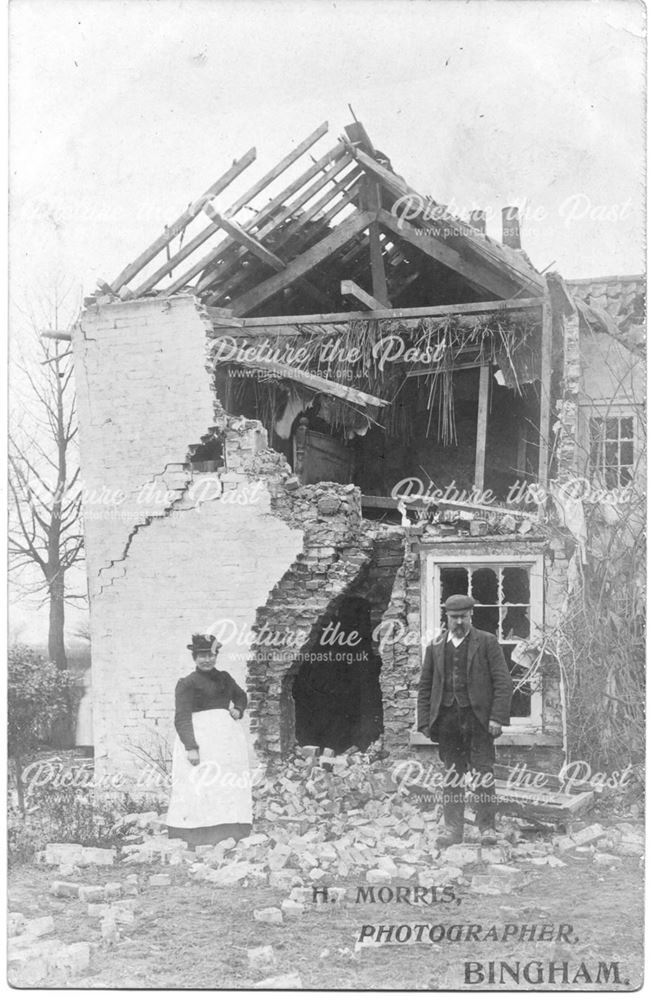 A couple standing beside a half-demolished house