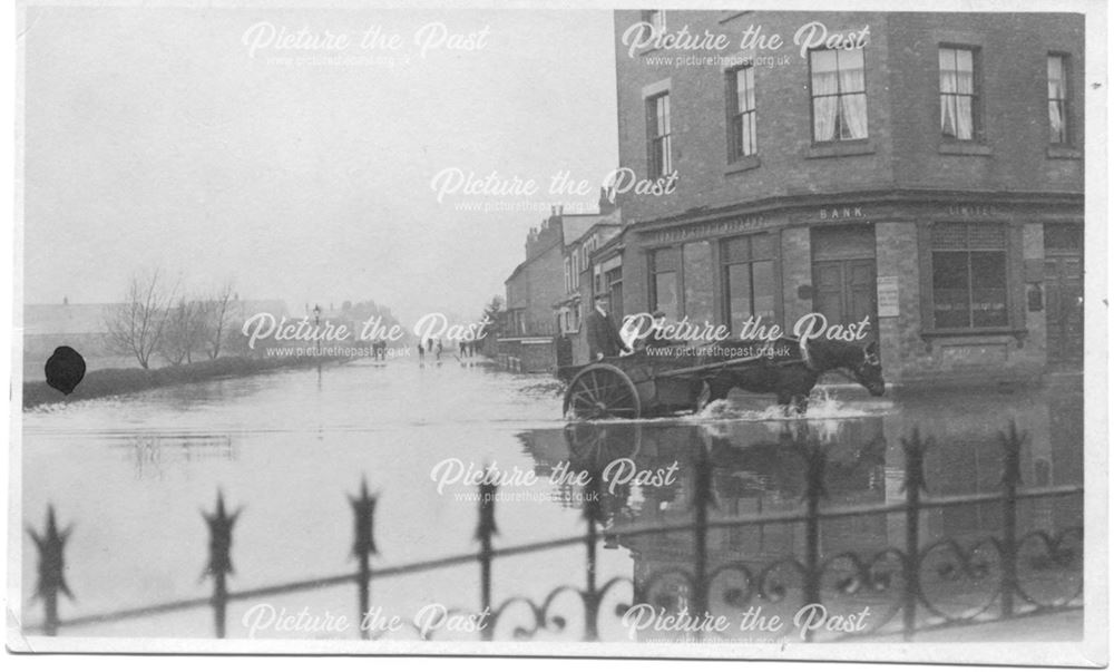 Flooded street with horse and cart outside a bank, 1932