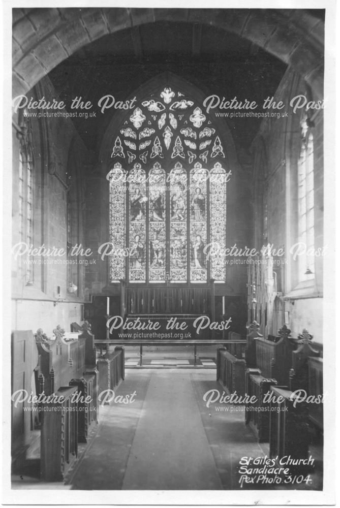 An interior shot of the parish church, showing the altar, stained glass window and choir stalls.