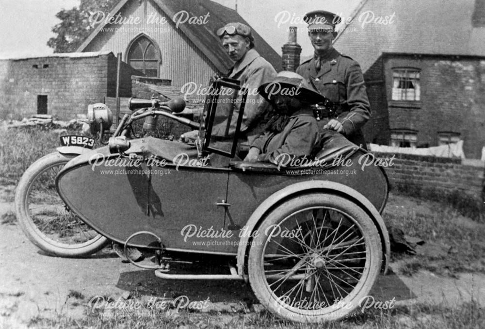 Ted Henson standing by a motorcycle and side car after World War 1