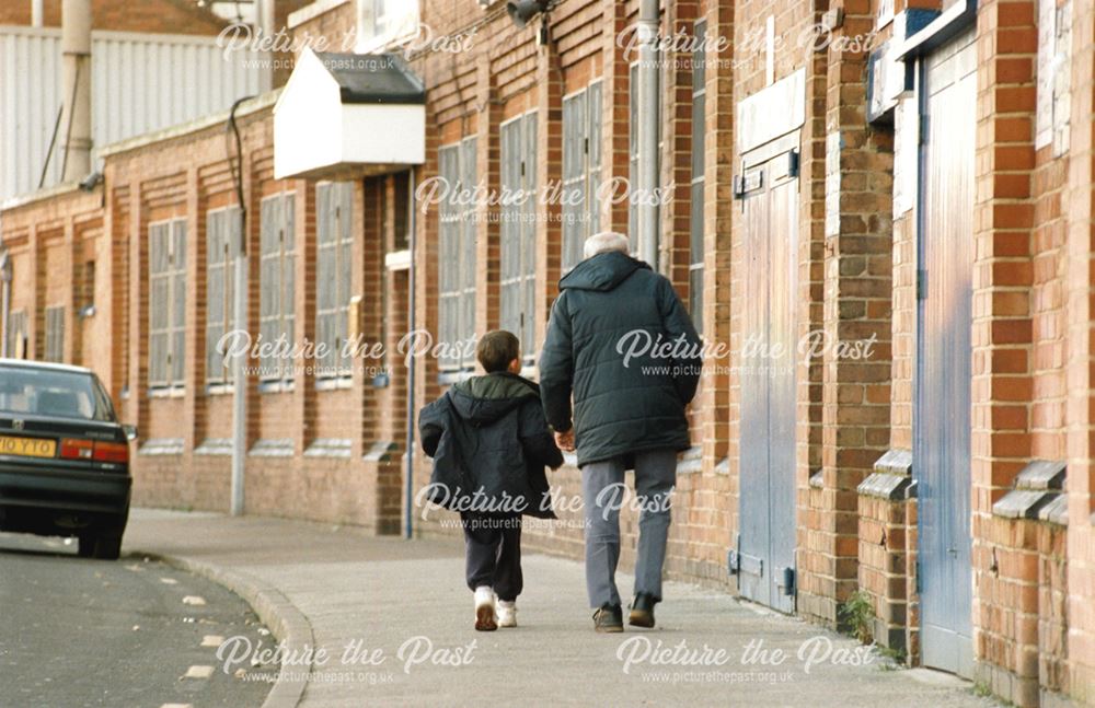 Exterior of The Baseball Ground, Man and boy walking.