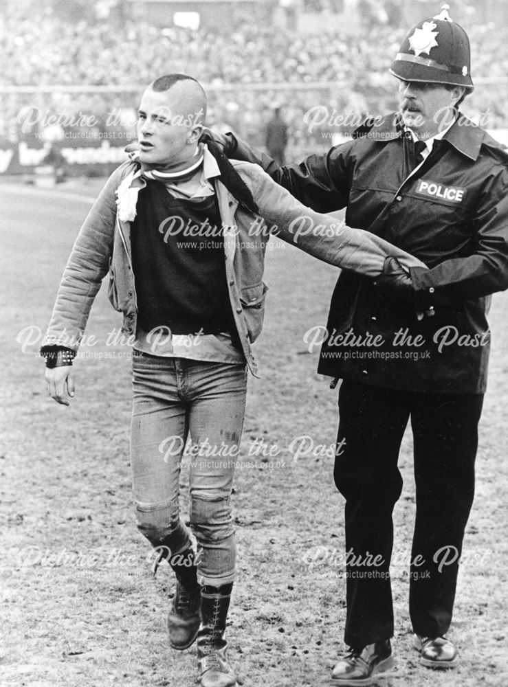 A Hooligan is led away by a Police Officer at Derby County vs Plymouth, 1984