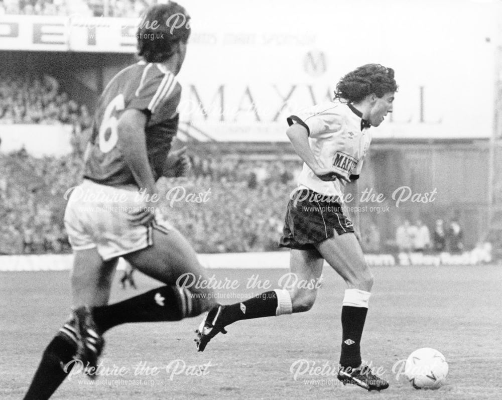 Derby County striker Dean Saunders runs past a Manchester United player